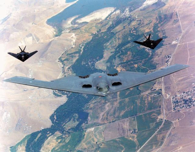 B2 stealth bomber being escorted by two F117 fighter jets