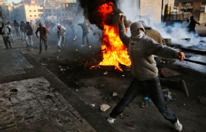 Palestinian protester throws stones at Israeli troops near Shuafat refugee camp