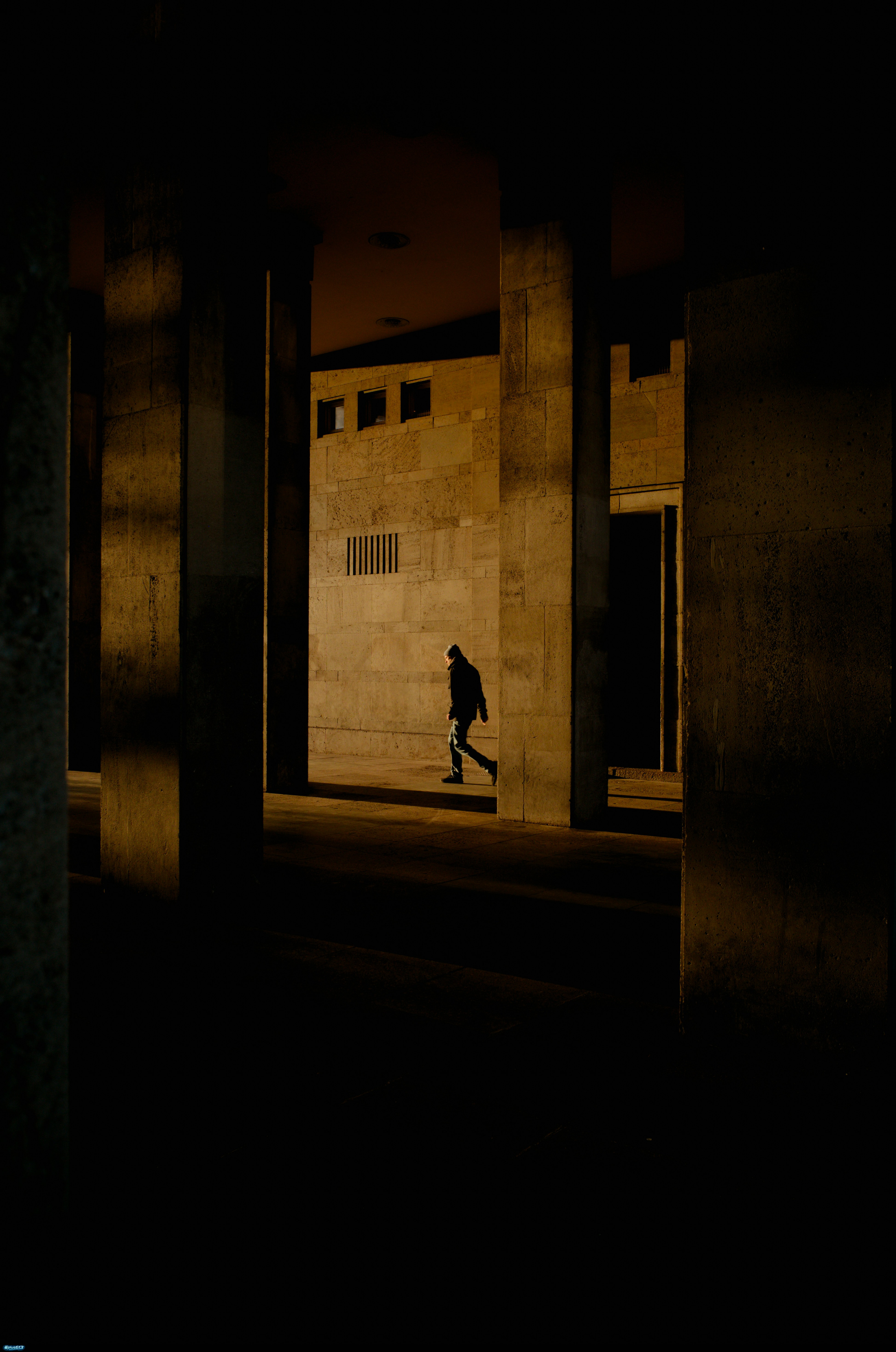 Silhouette of a person walking in a dark urban underpass by Pavel Moiseev