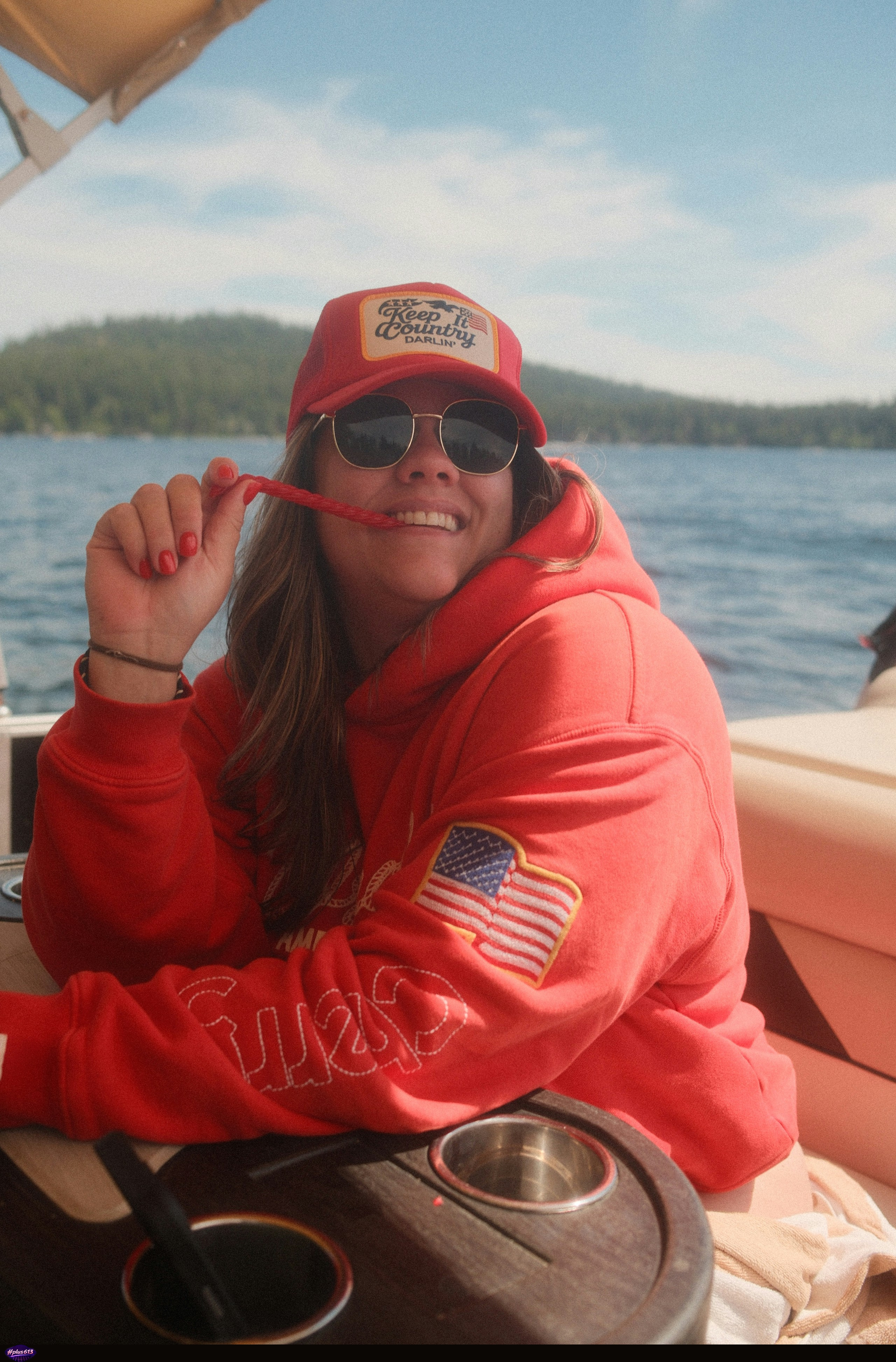 Smiling woman in red hoodie on lake by Karsten Winegeart