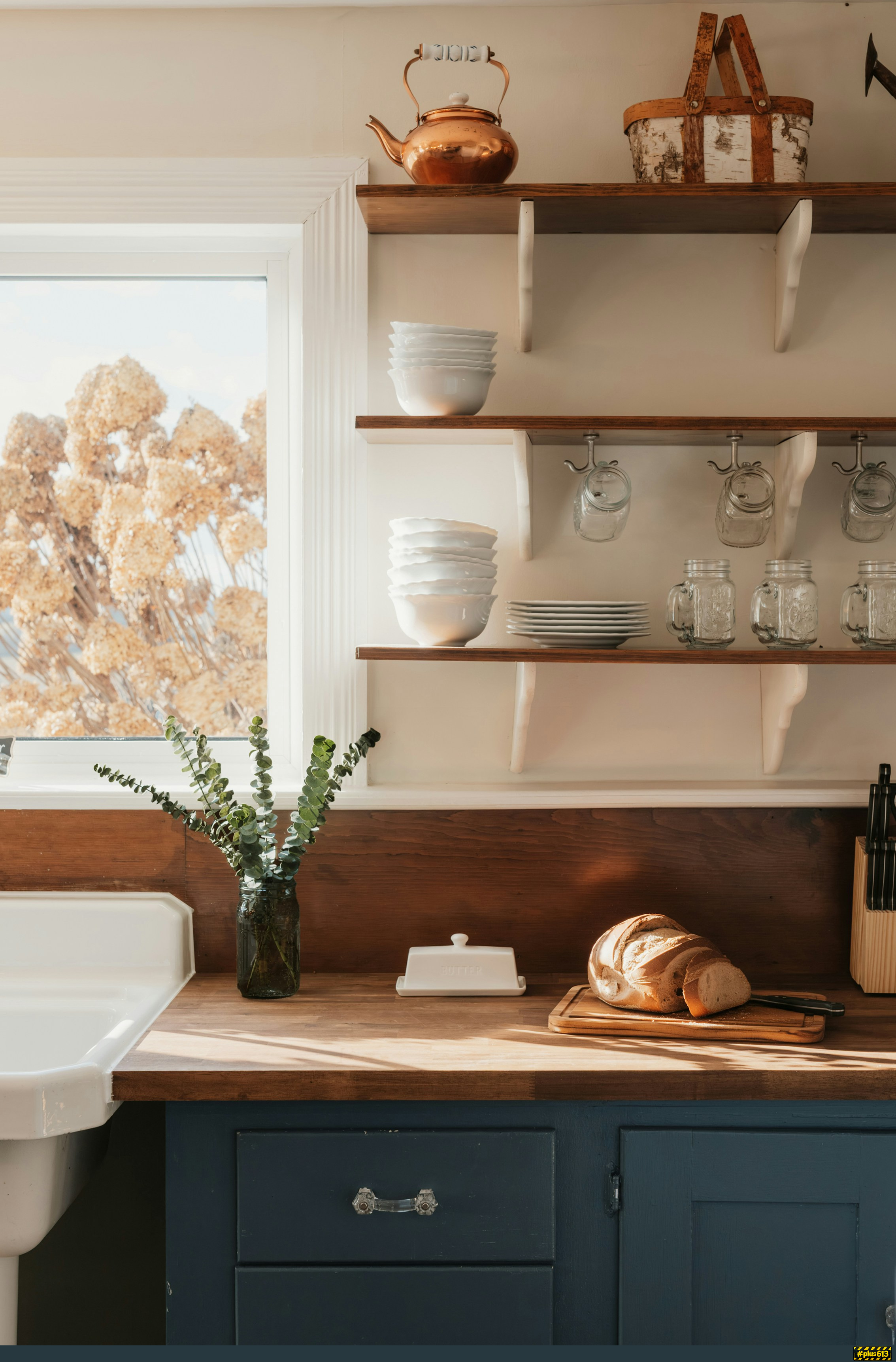 Rustic kitchen counter with bread and dishes by Clay Banks