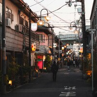 Urban street at dusk with people and illuminated lanterns by Alexander Kaufmann